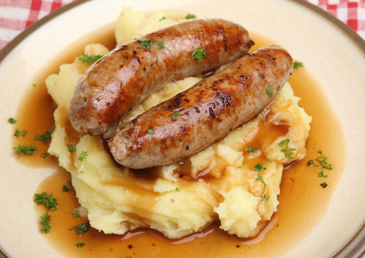 a plate of traditional banger sausage on mashed potatoes and gravy