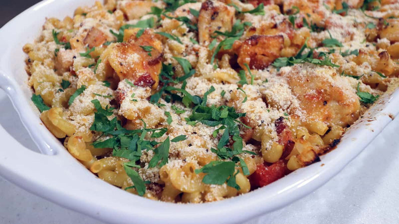 Macaroni and cheese dish with herbs in a white bowl