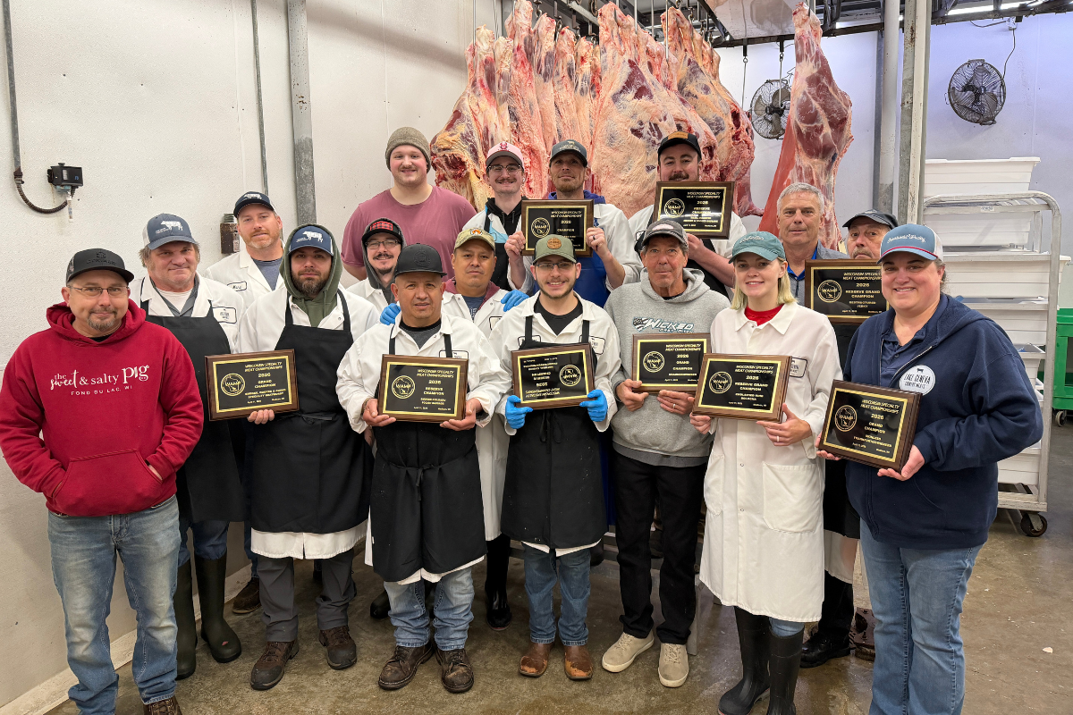 Group of people holding awards in a meat processing plant.