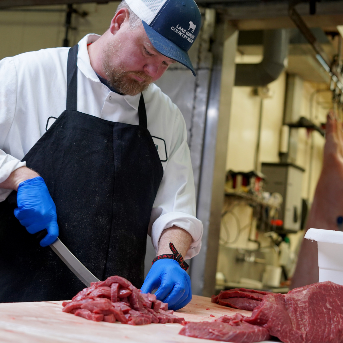 a butcher cutting beef stew meat