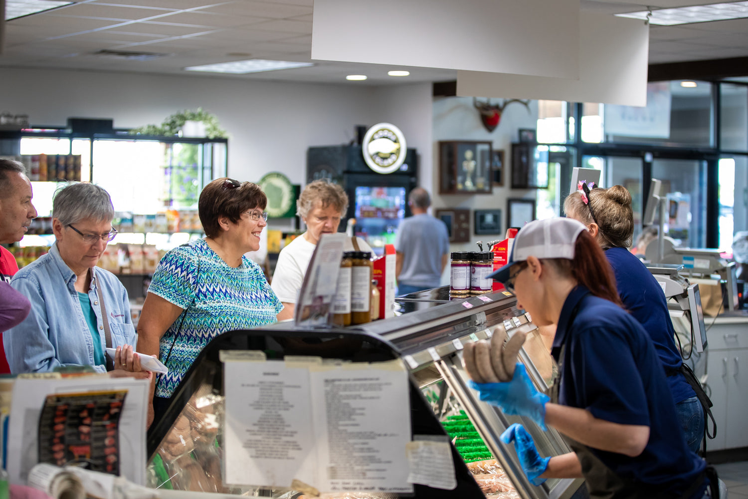 Customers shopping at a meat counter