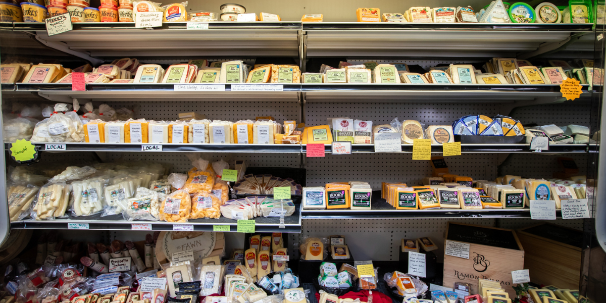 Grocery store shelves stocked with various food items including cheese and packaged goods.