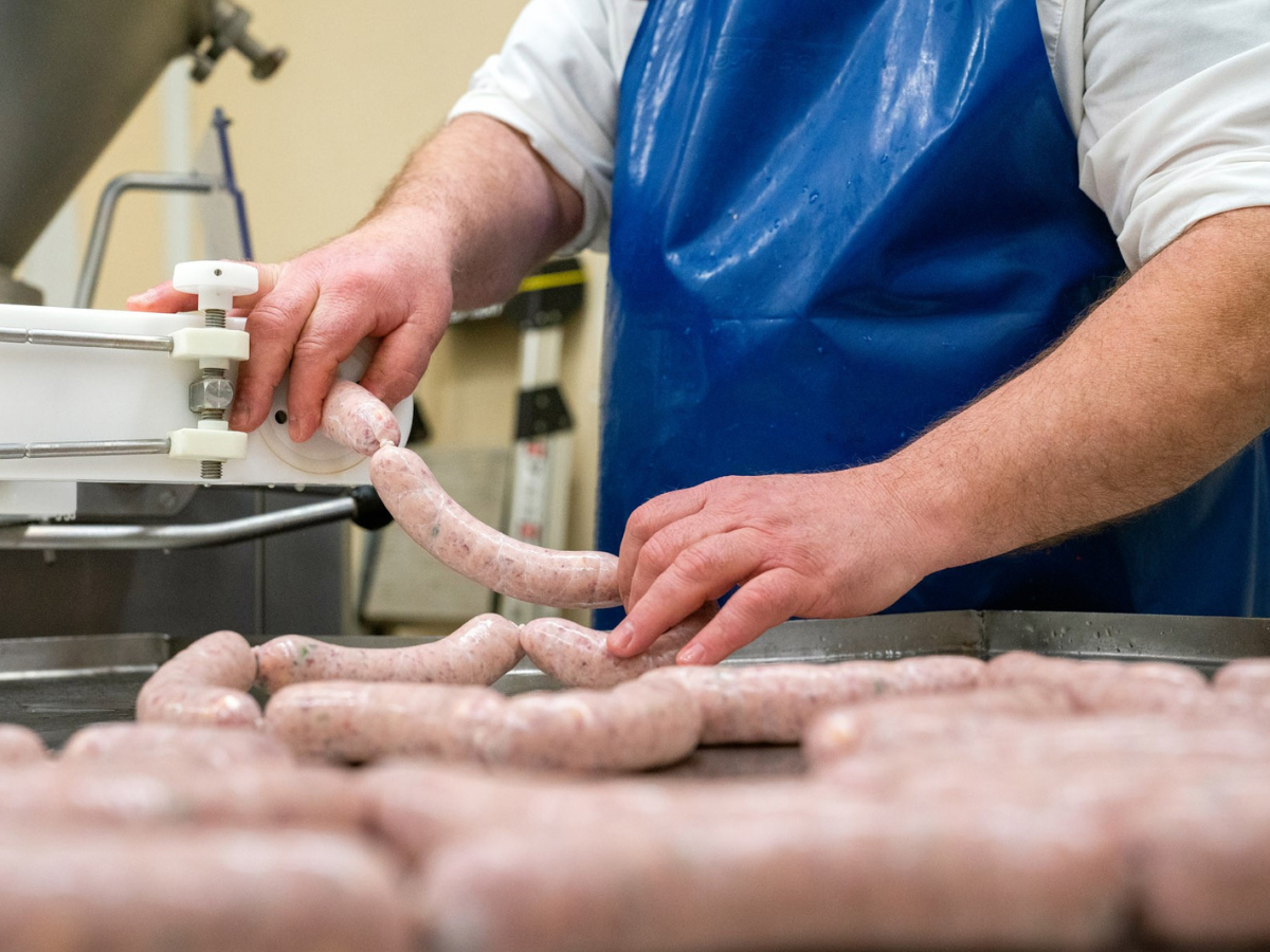 a butcher stuffing sausages