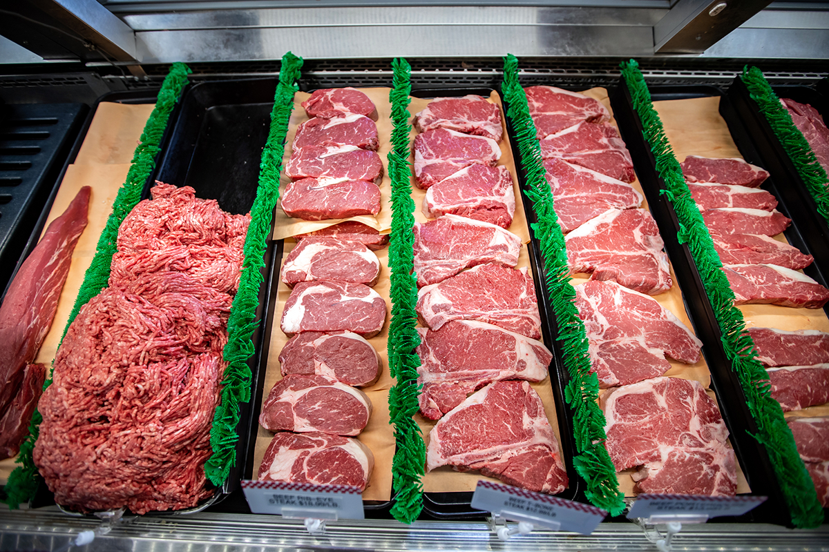 cuts of beef steak and ground beef in a meat case