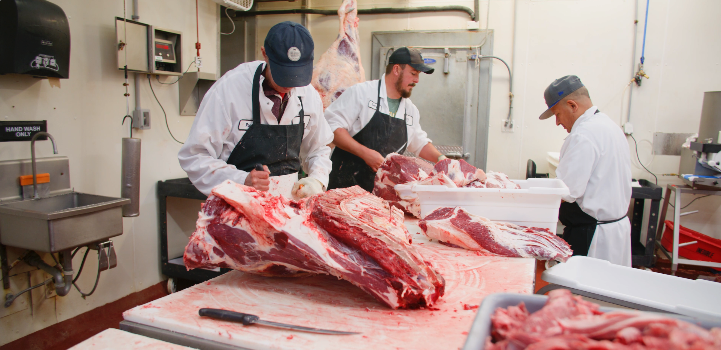 butchers cutting beef into primals