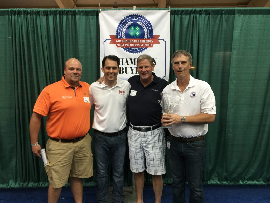 From L-R, Matt Larse of Town Bank, Governor Scott Walker, Mike Jackson of Town Bank, and Scott Vorpagel of LGCM at the Governor's 4H Blue Ribbon Auction at the WI State Fair with our award for Best in Show product!