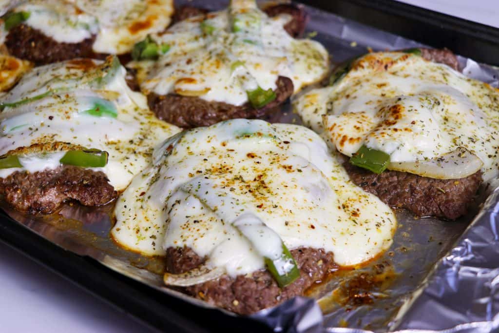 steaks on a tray with cheese on top